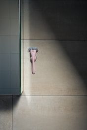 A smart razor with digital display and ergonomic grip on a marble sink.