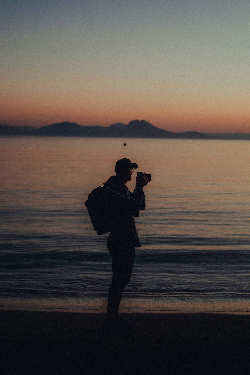 a man standing on a beach holding a camera