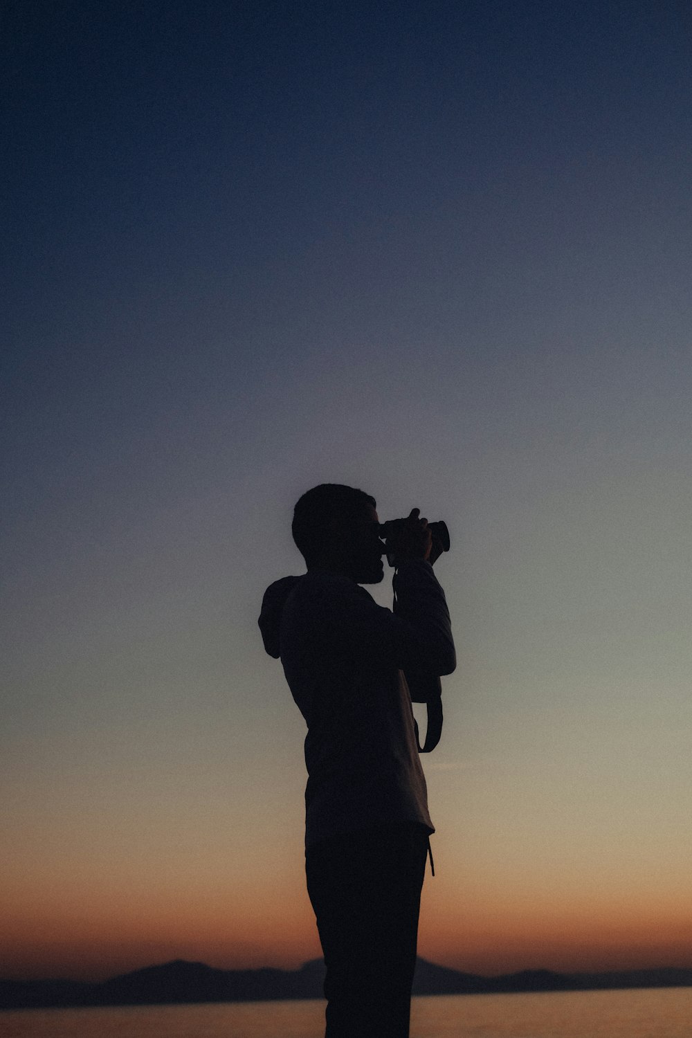 a person standing on a beach with a camera