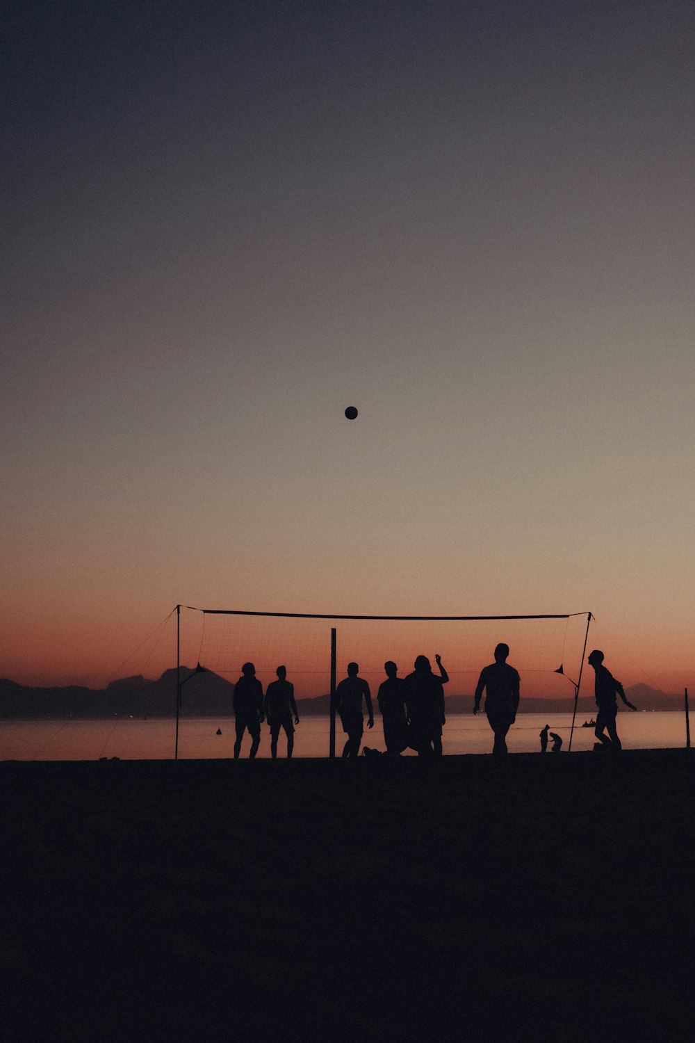 a group of people standing on top of a beach