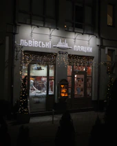 A small business storefront glowing warmly in golden hour sunlight.