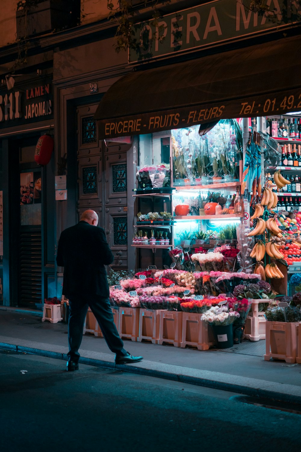 a man walking down the street in front of a store