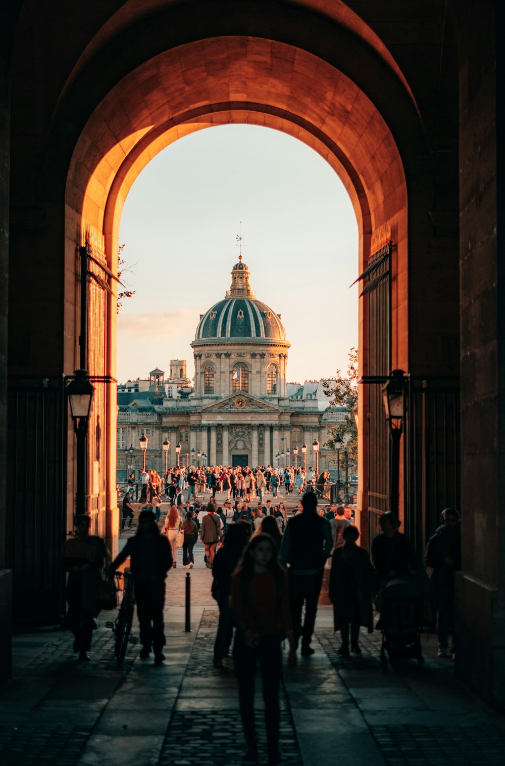 a group of people walking under an archway