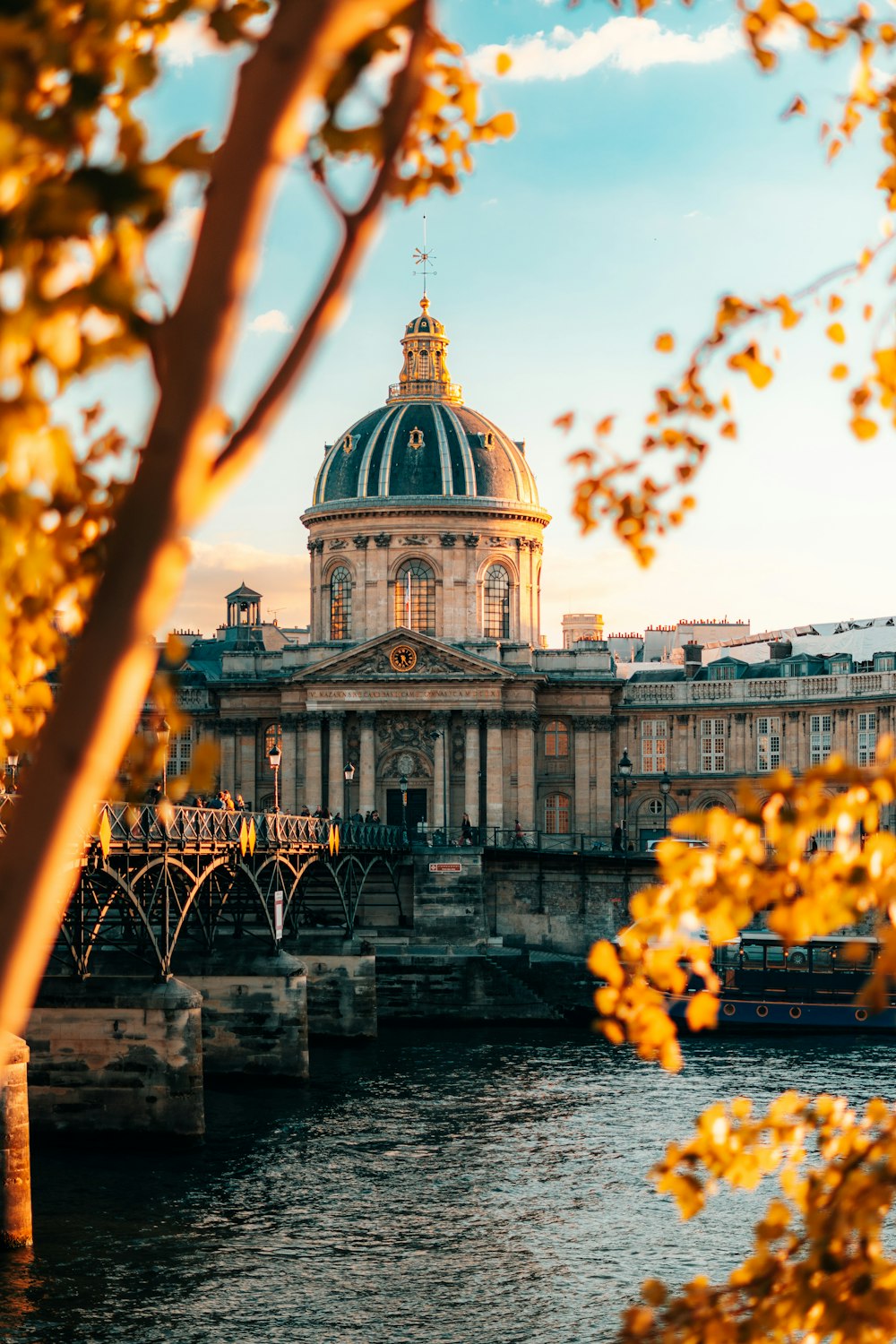 a large building sitting on top of a river next to a bridge