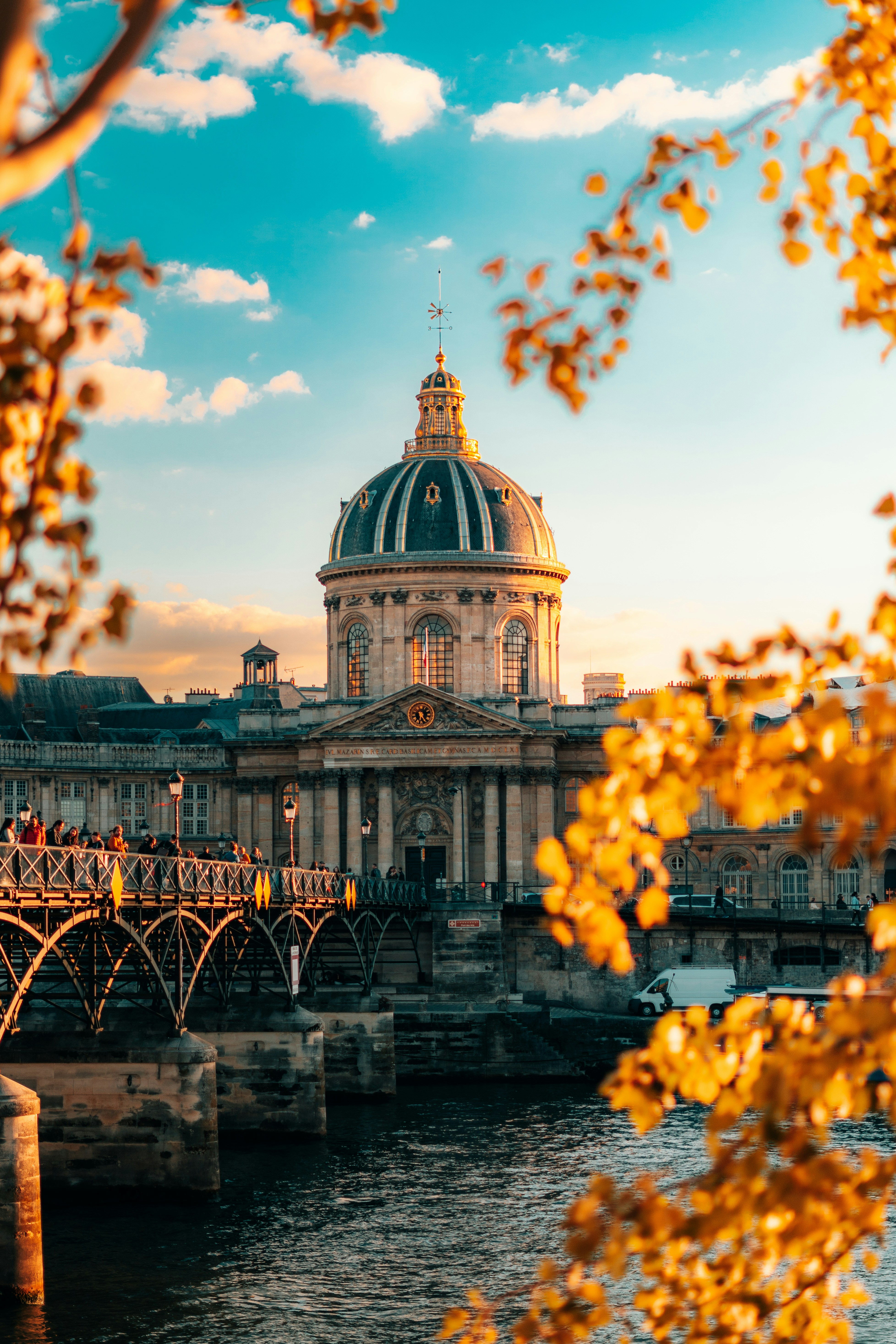 a large building sitting on top of a river next to a bridge