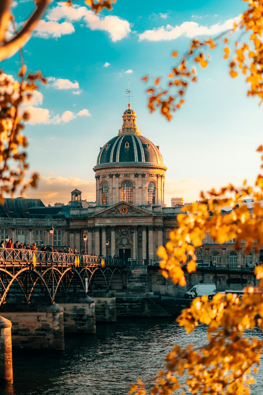 a large building sitting on top of a river next to a bridge