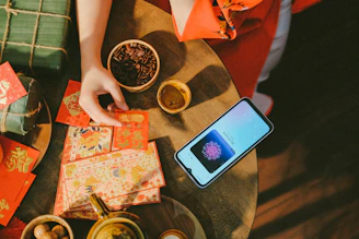 a person sitting at a table with a cell phone