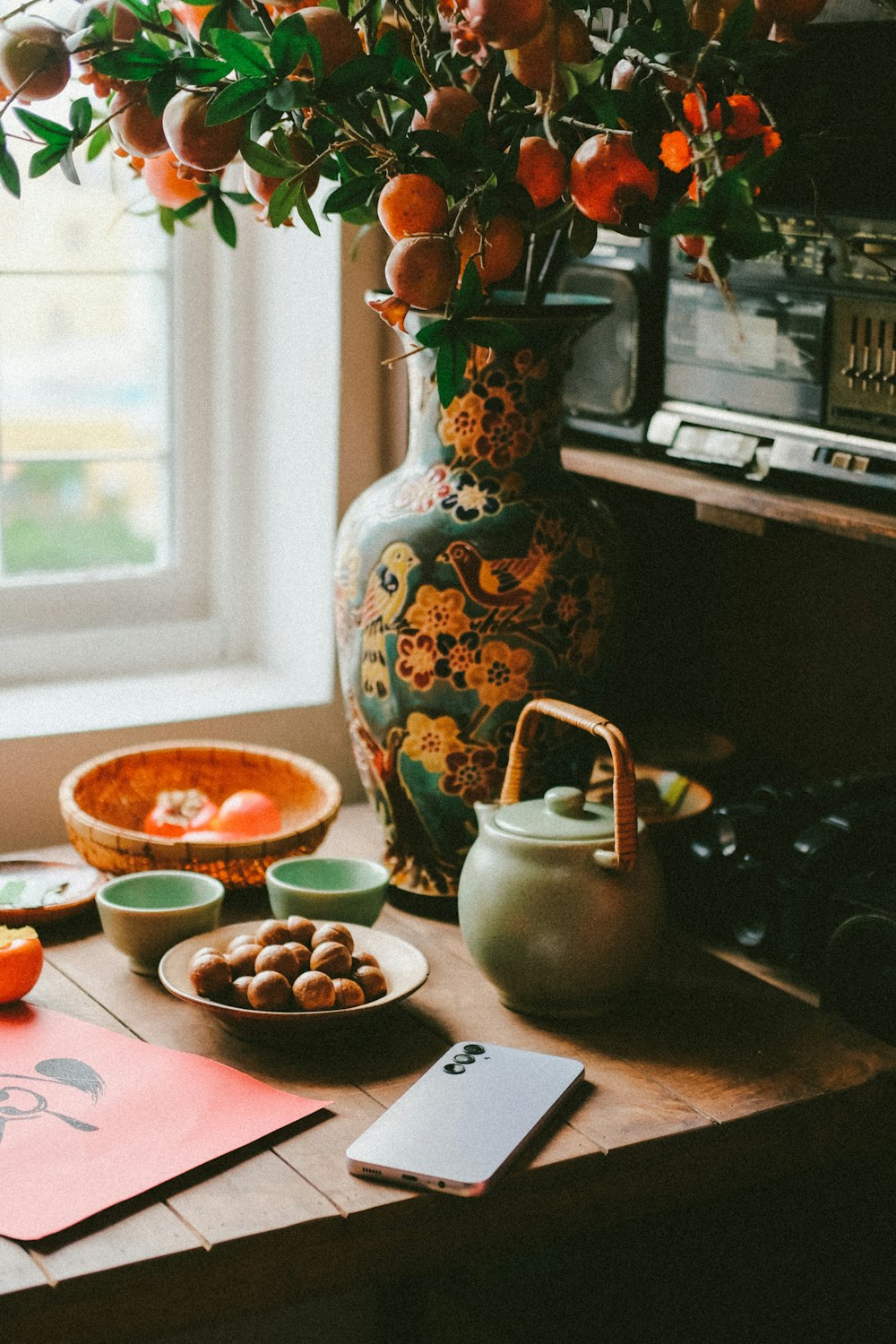 a wooden table topped with a vase filled with oranges