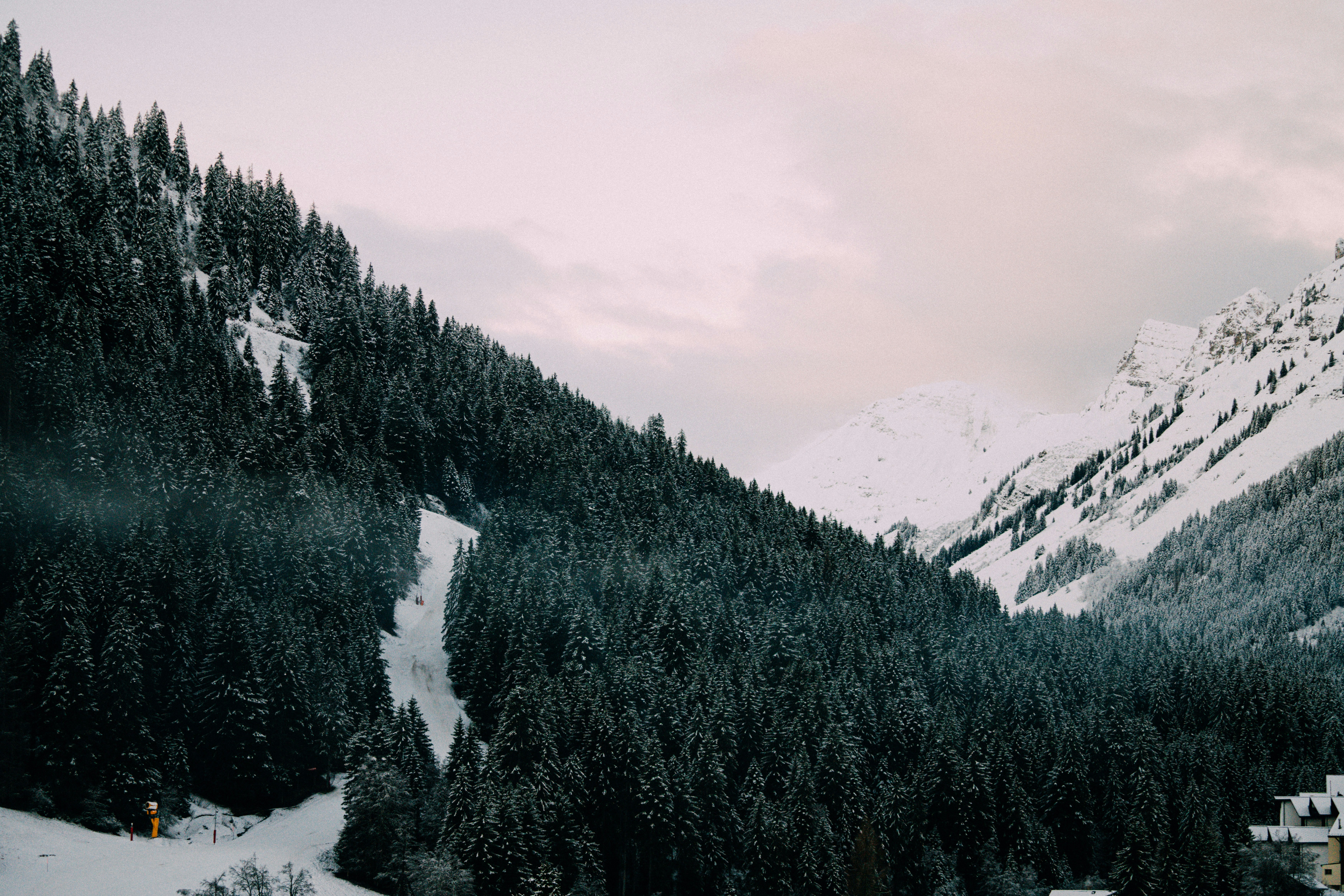 Une montagne enneigée avec une maison au premier plan