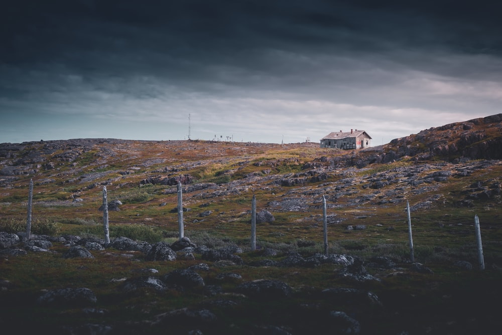 a house on a hill with a dark sky in the background