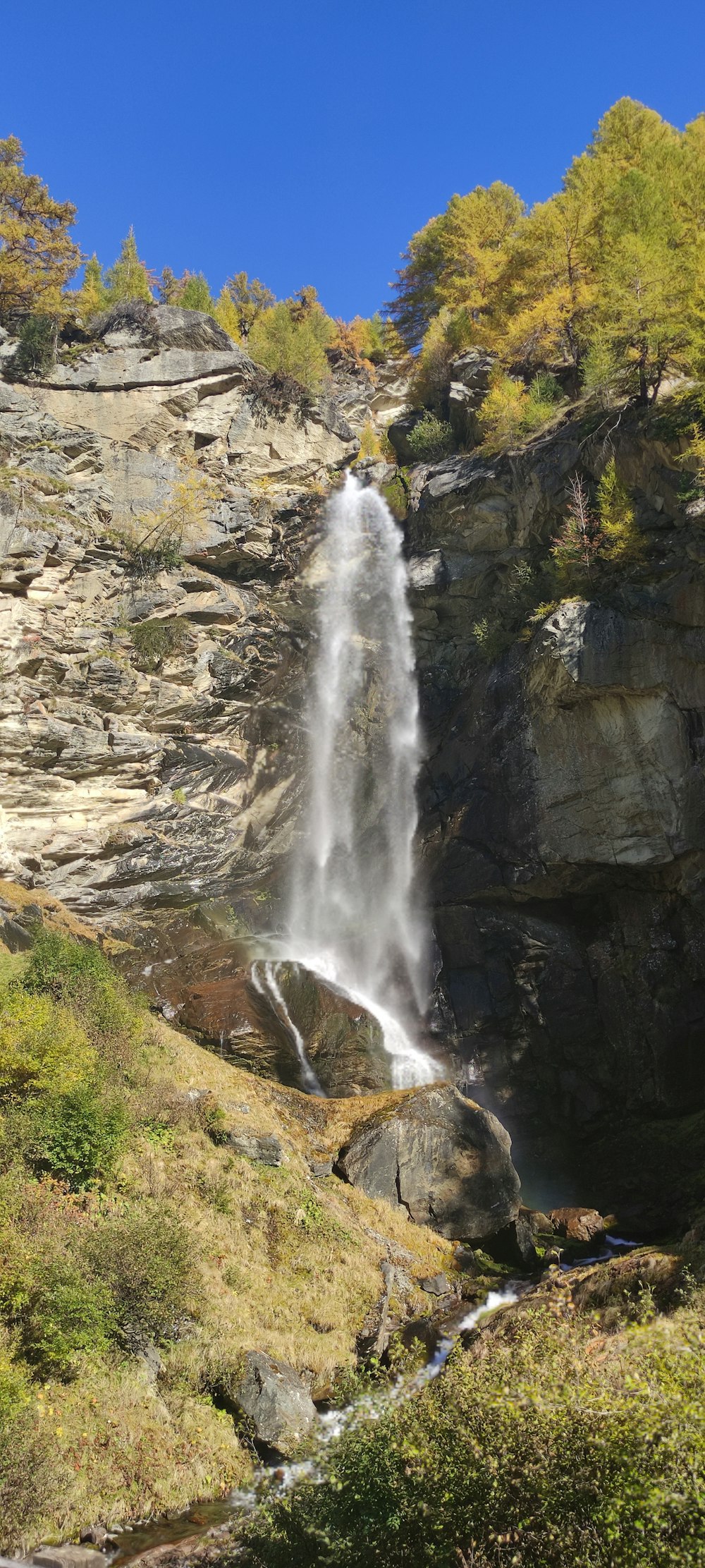 a tall waterfall with water cascading down it's side