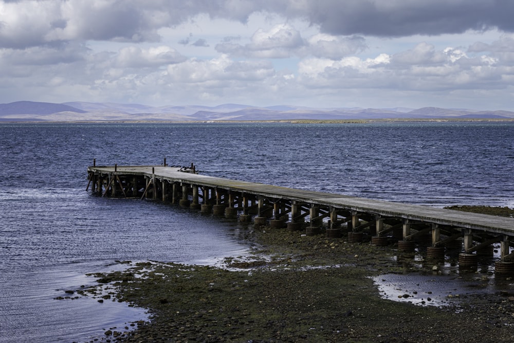 a long wooden pier sitting on top of a body of water