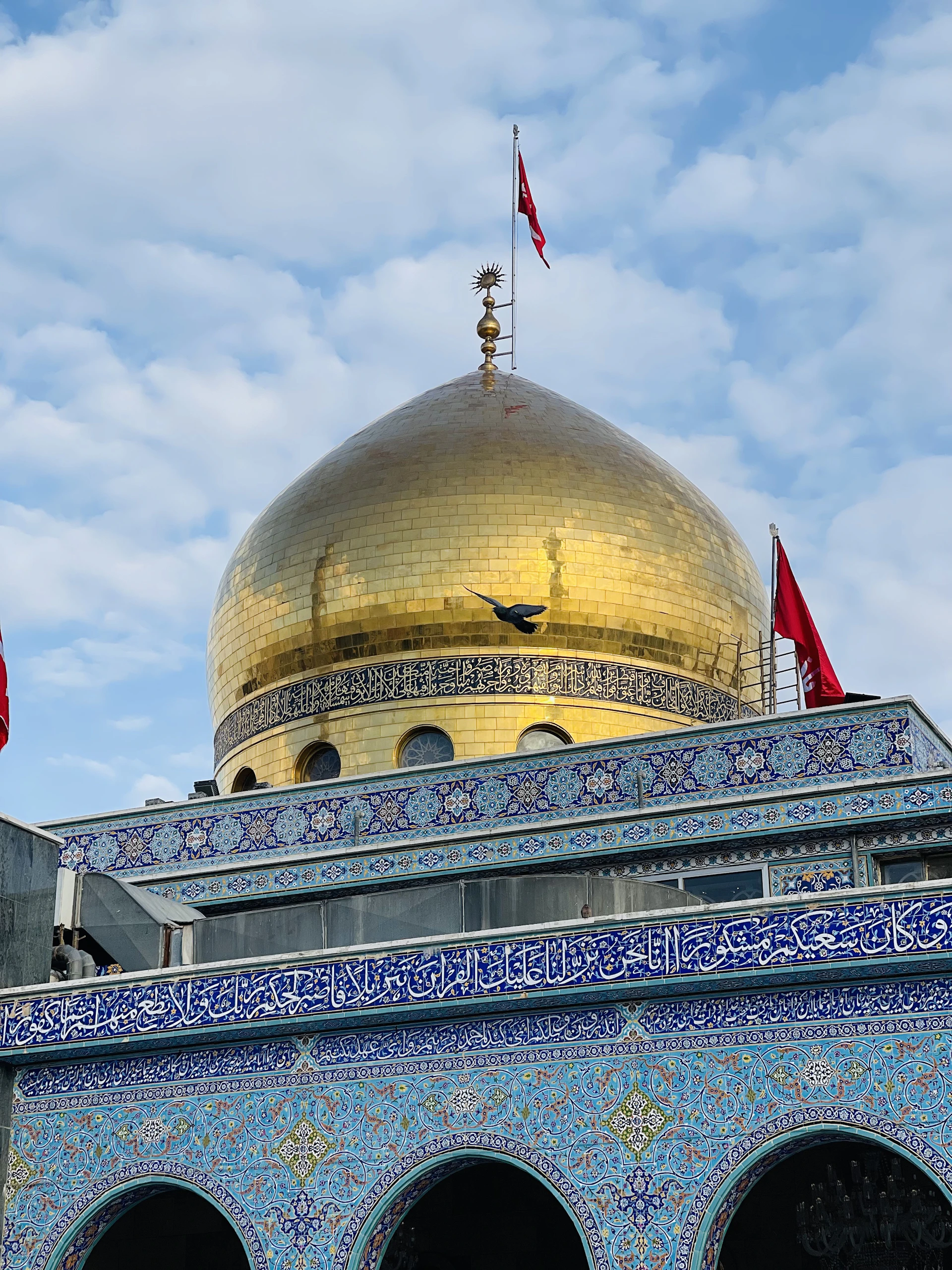 the dome of a building with two flags on top of it