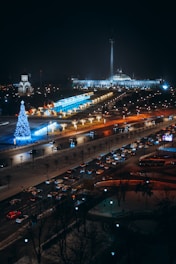 a city street at night with a lit up christmas tree