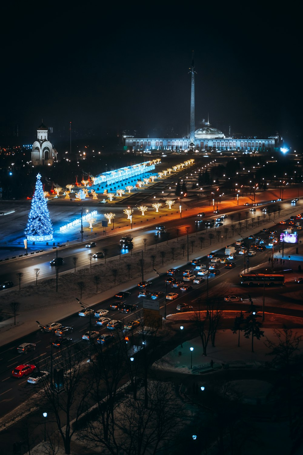 Una strada della città di notte con un albero di Natale illuminato