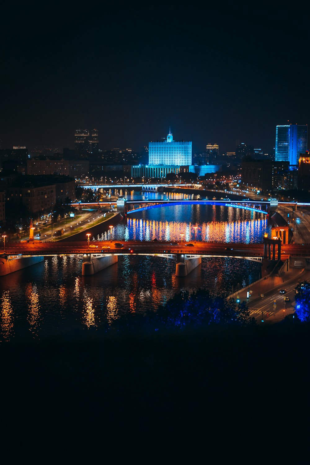 Una vista di una città di notte dall'altra parte del fiume