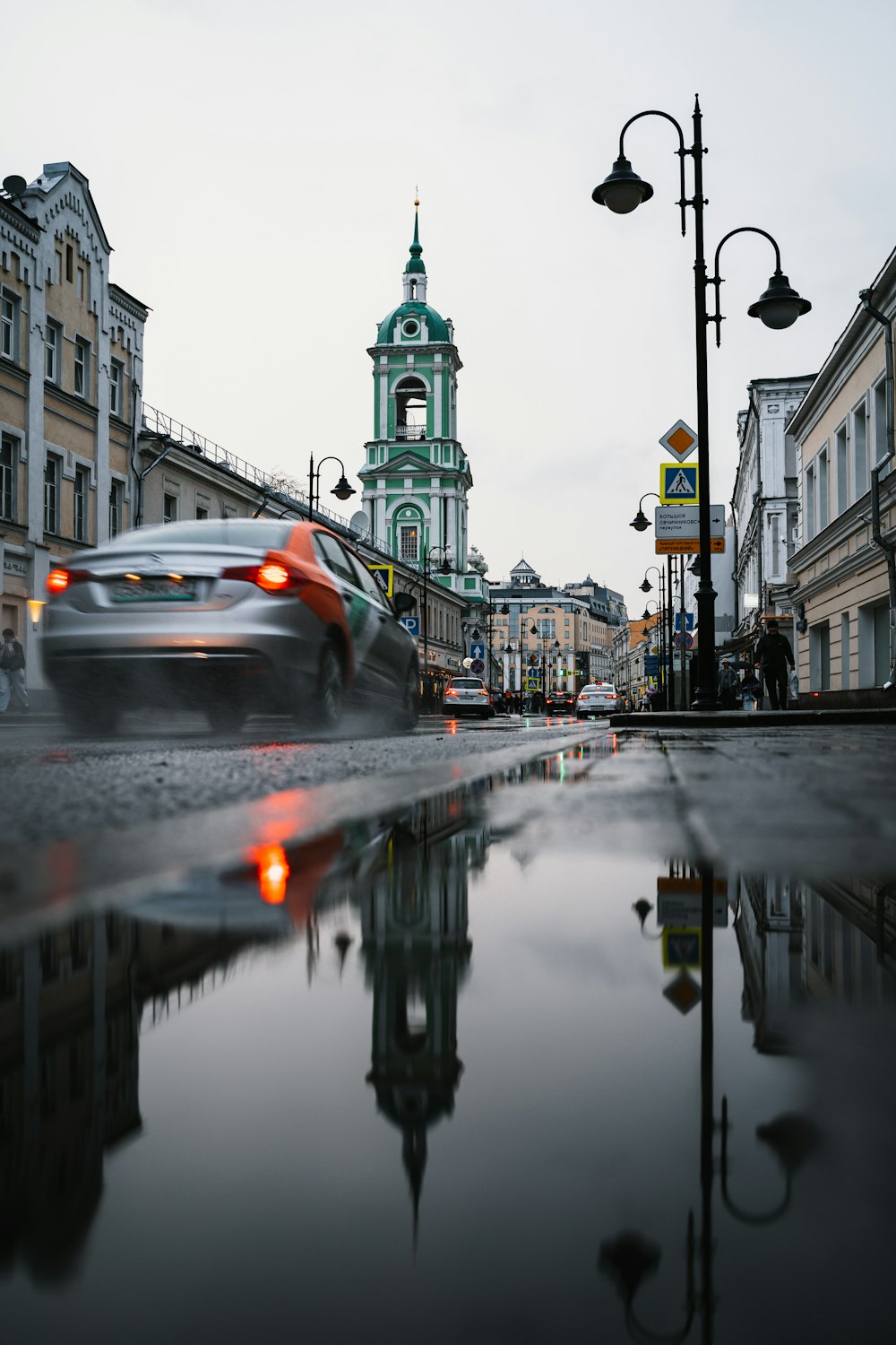 a car driving down a street next to tall buildings