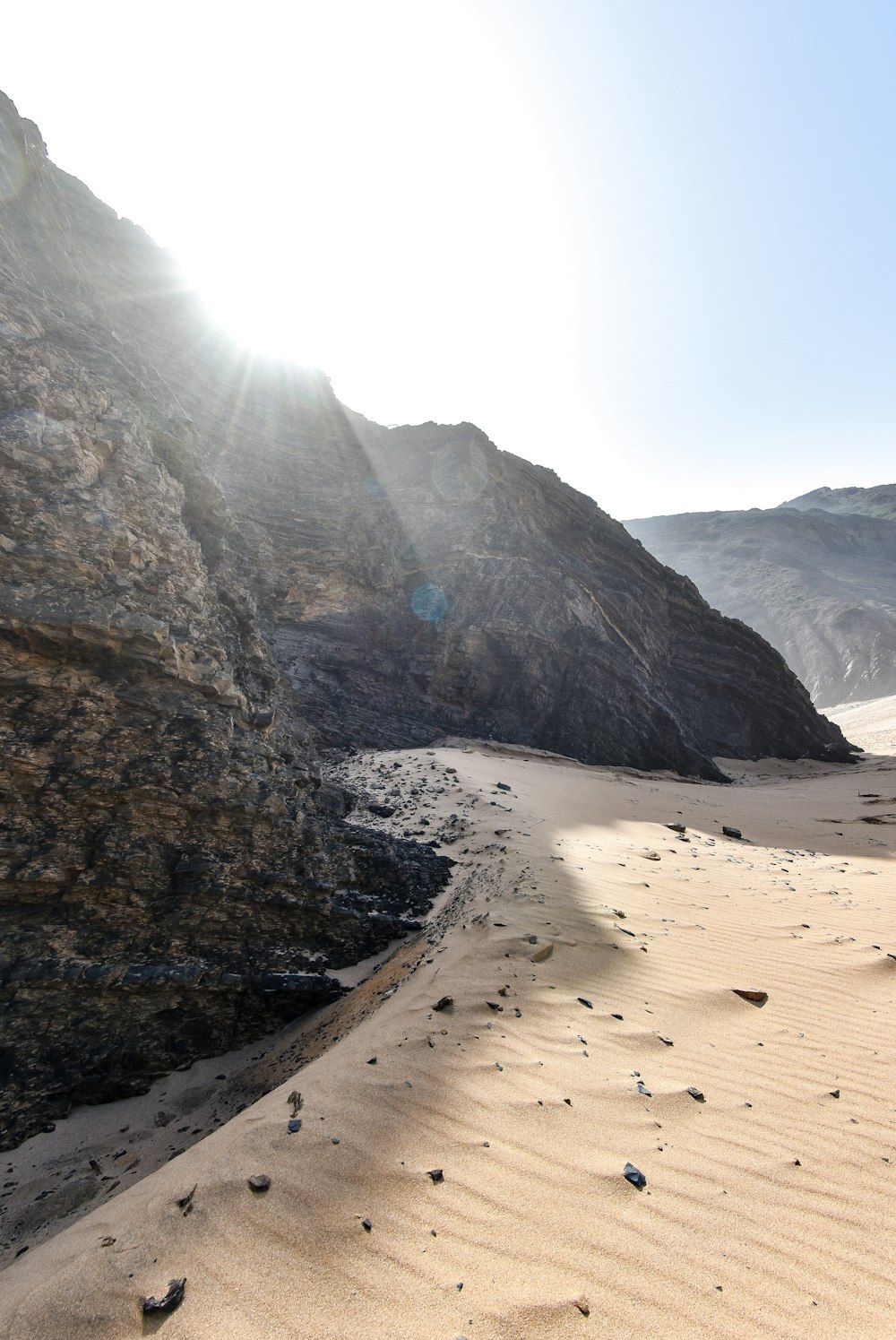 the sun shines brightly on a sandy beach