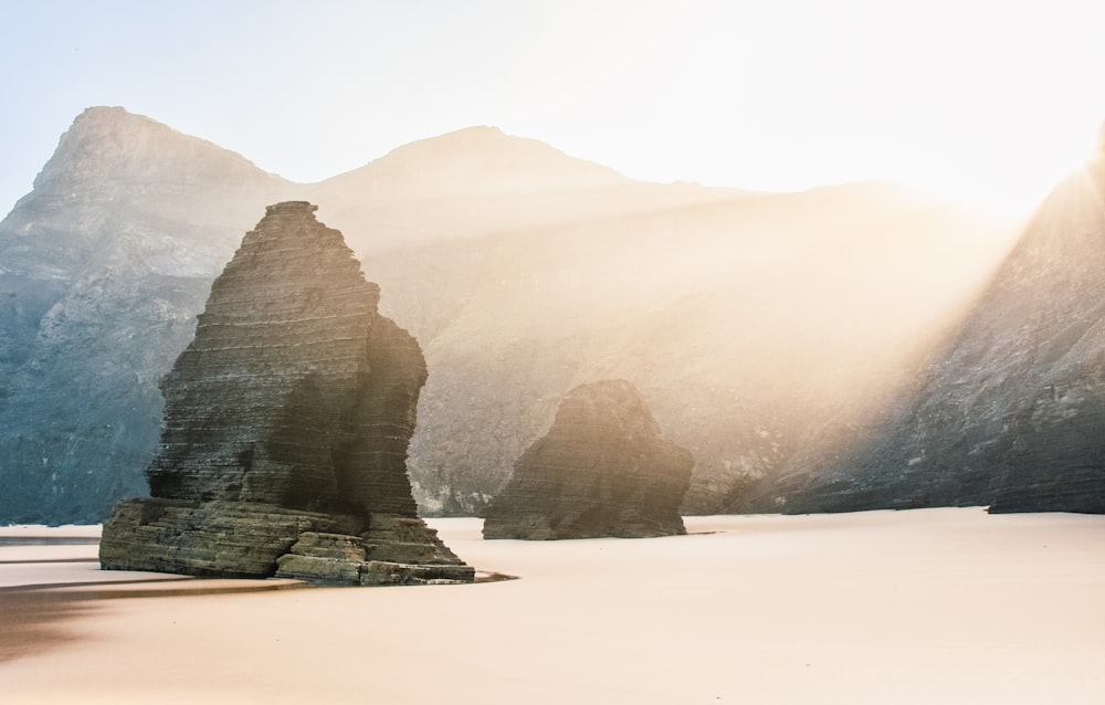 the sun is shining through the mountains and rocks