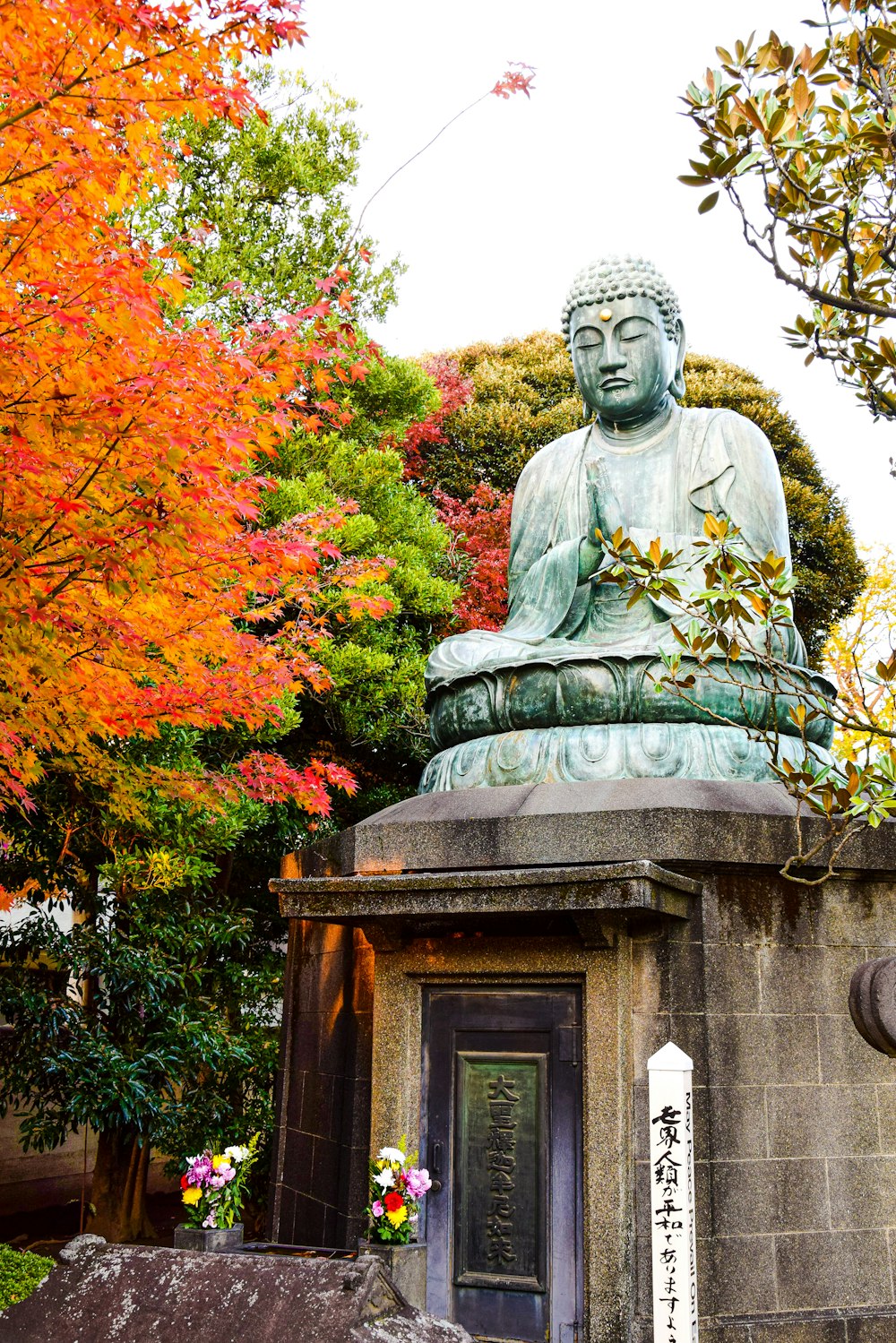 a statue of a buddha in front of some trees