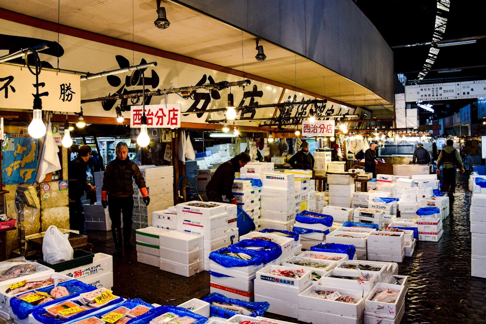 a group of people standing around boxes of food