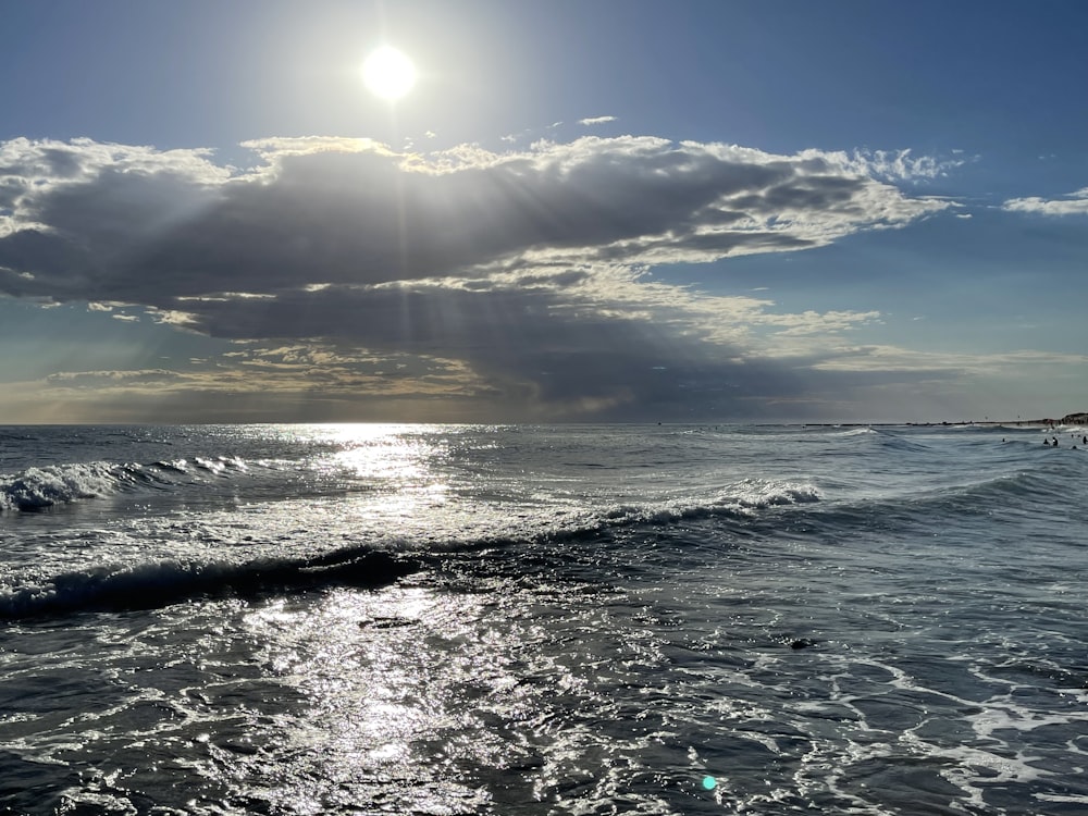 o sol brilhando através das nuvens sobre o oceano