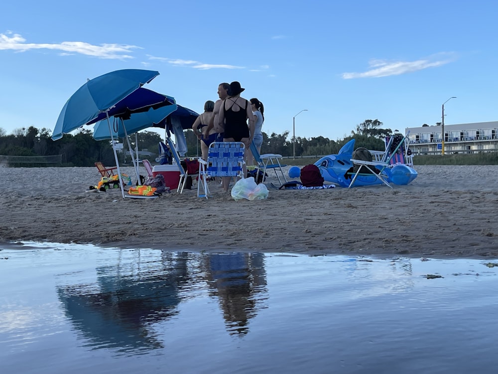 a group of people standing on top of a sandy beach