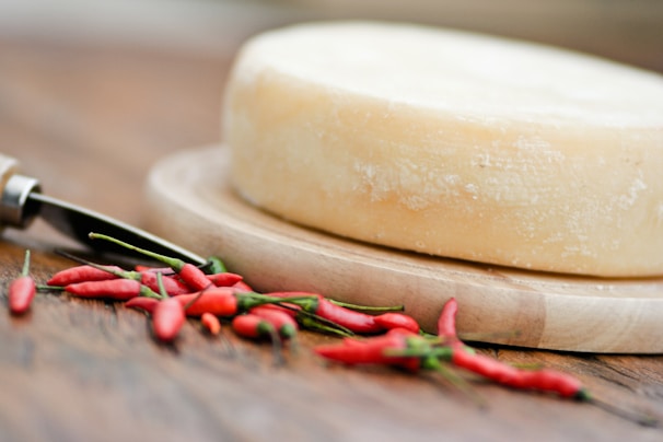 Close-up of traditional hard chhurpi cheese pieces stacked on rustic wooden board with Himalayan mountains in the background.