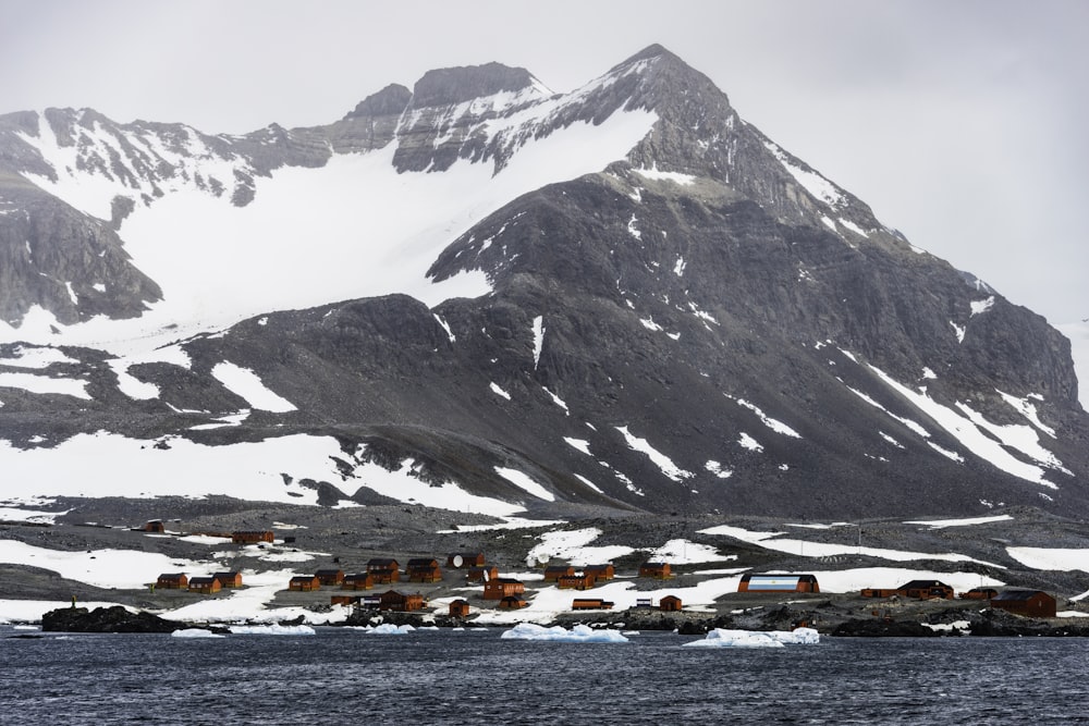 a snow covered mountain with a village in the foreground