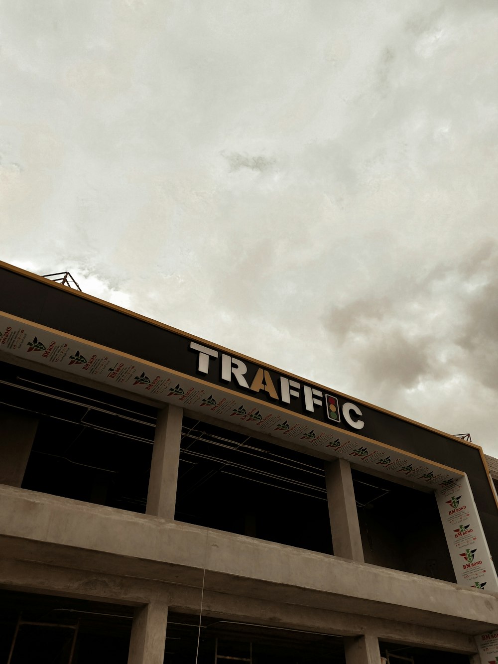 a traffic sign on top of a building under a cloudy sky
