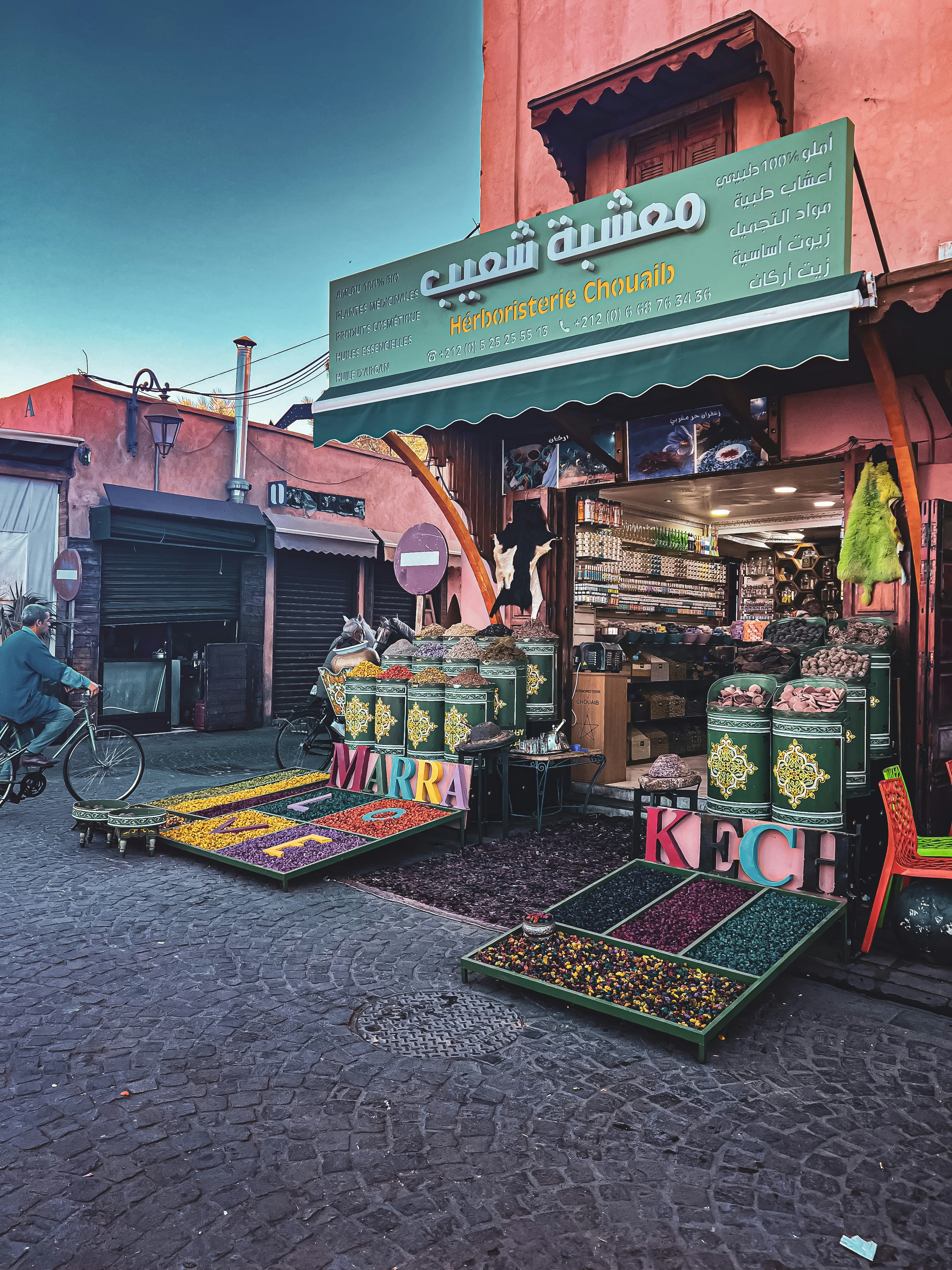 A man rides a bicycle past a traditional herbalist shop.