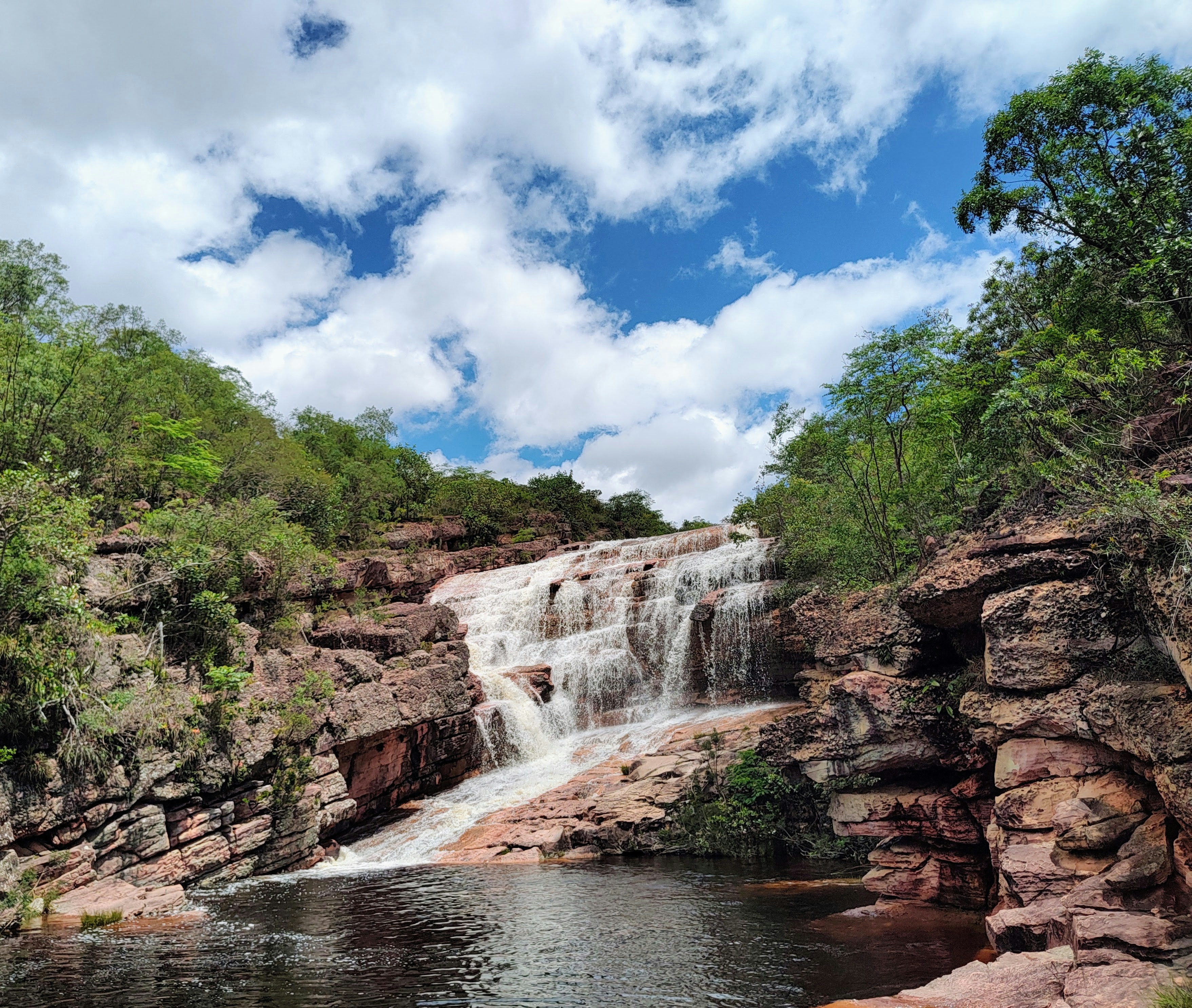 a large waterfall with a man swimming in it