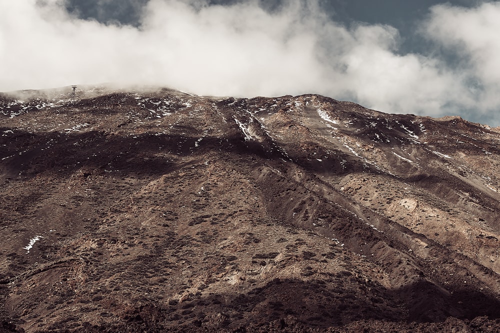 a very tall mountain covered in snow under a cloudy sky