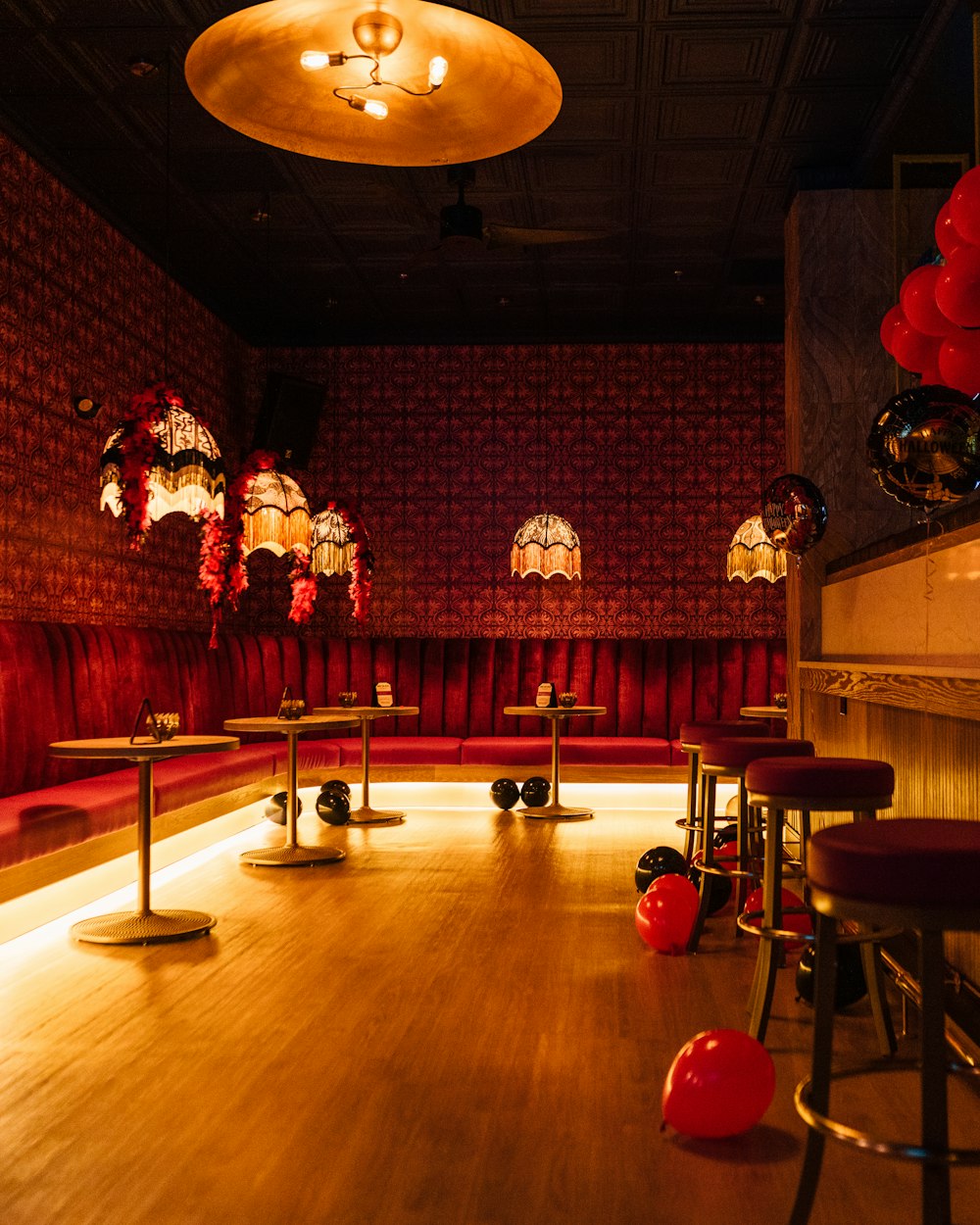 a dimly lit room with red couches and tables