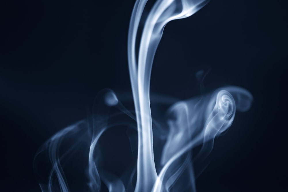 a blue smoke swirls across a black background