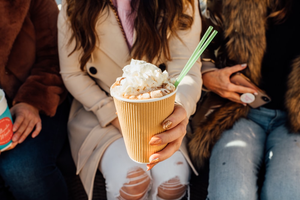 a woman holding a cup of ice cream