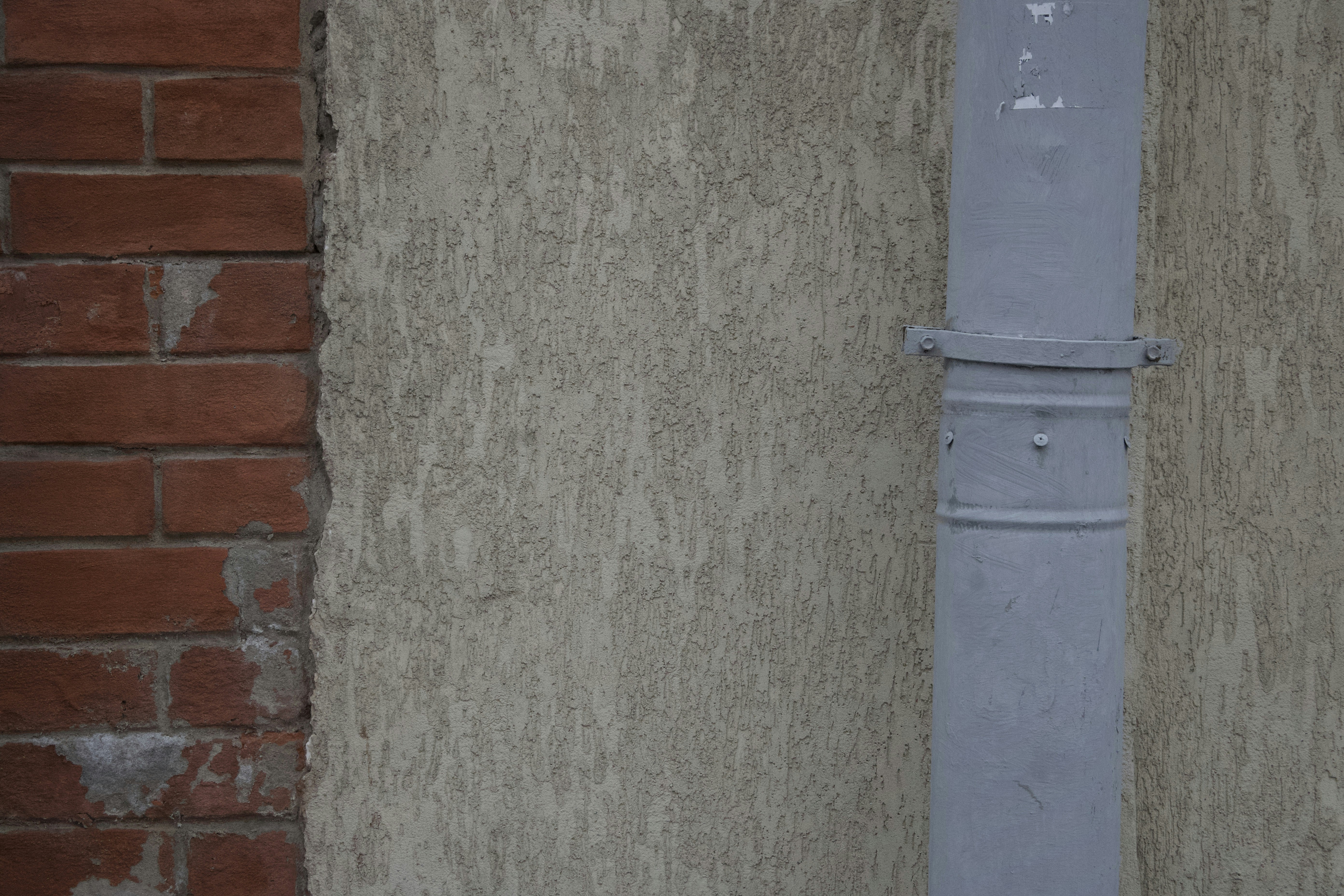 a blue street pole next to a brick wall