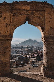 a view of a city through a stone arch