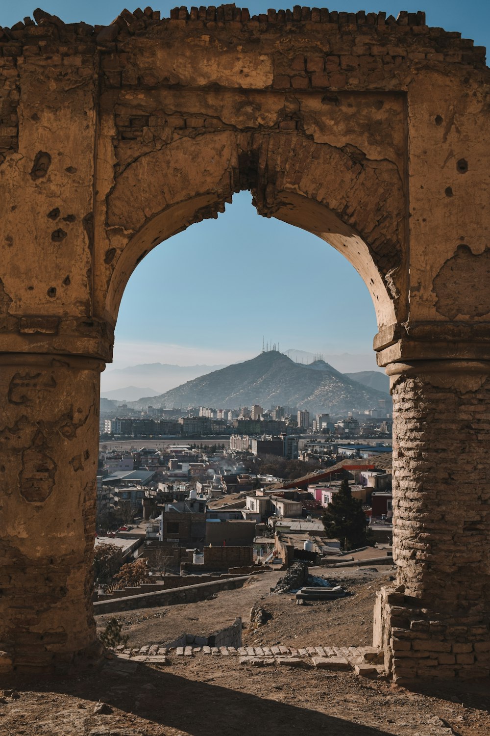 a view of a city through a stone arch