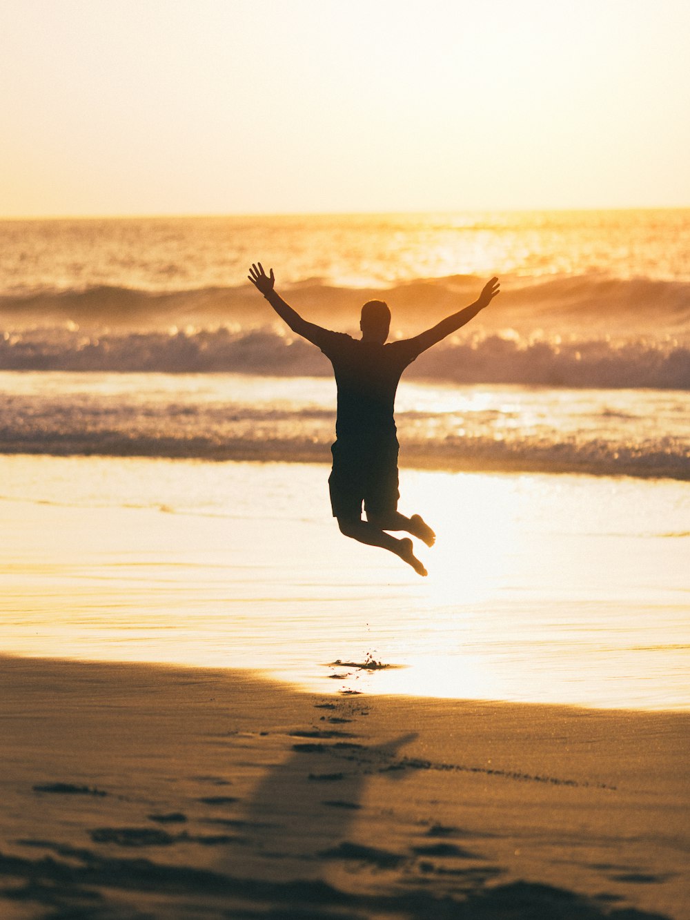 a person jumping in the air on a beach