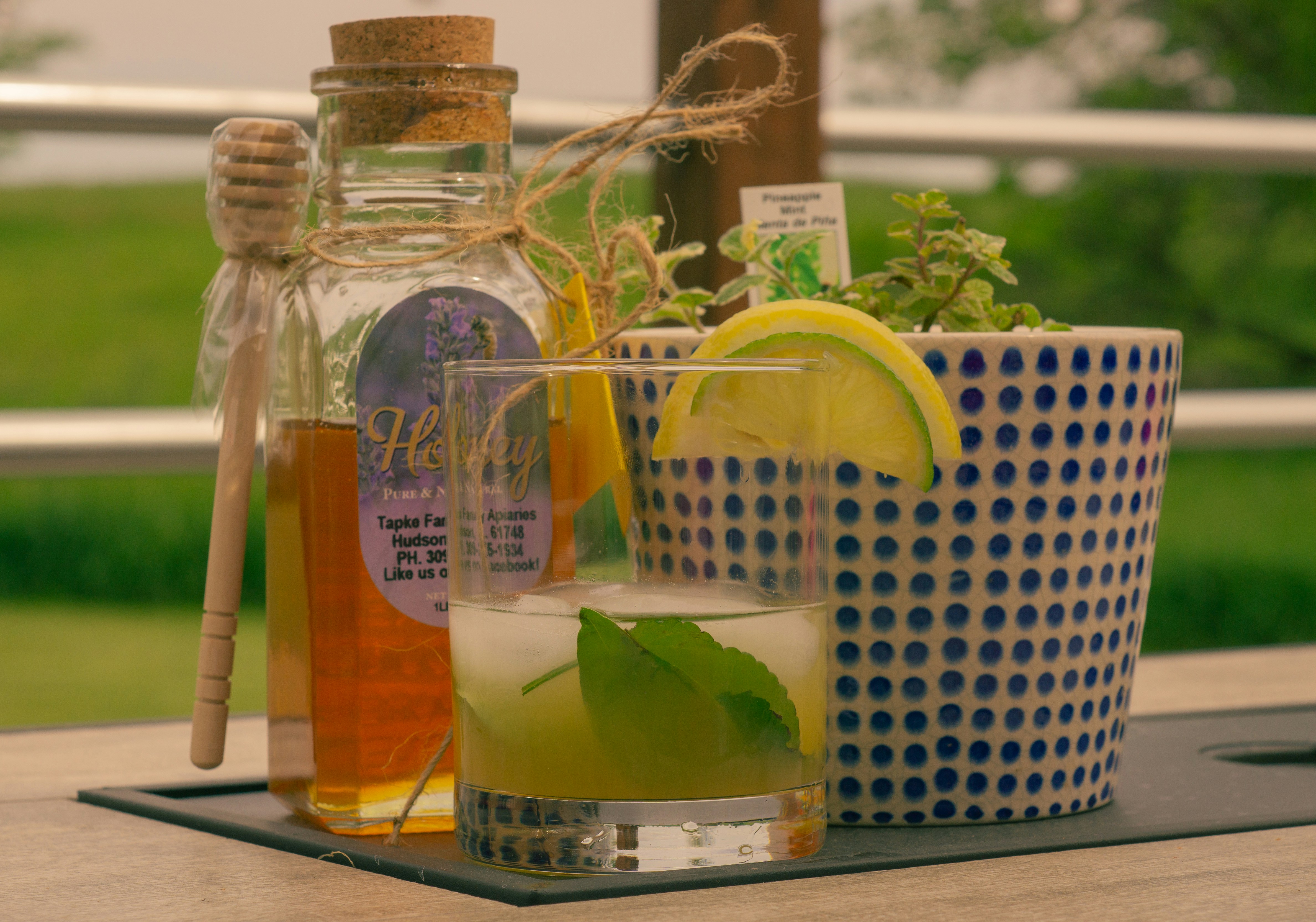 a glass of lemonade next to a bottle of lemonade