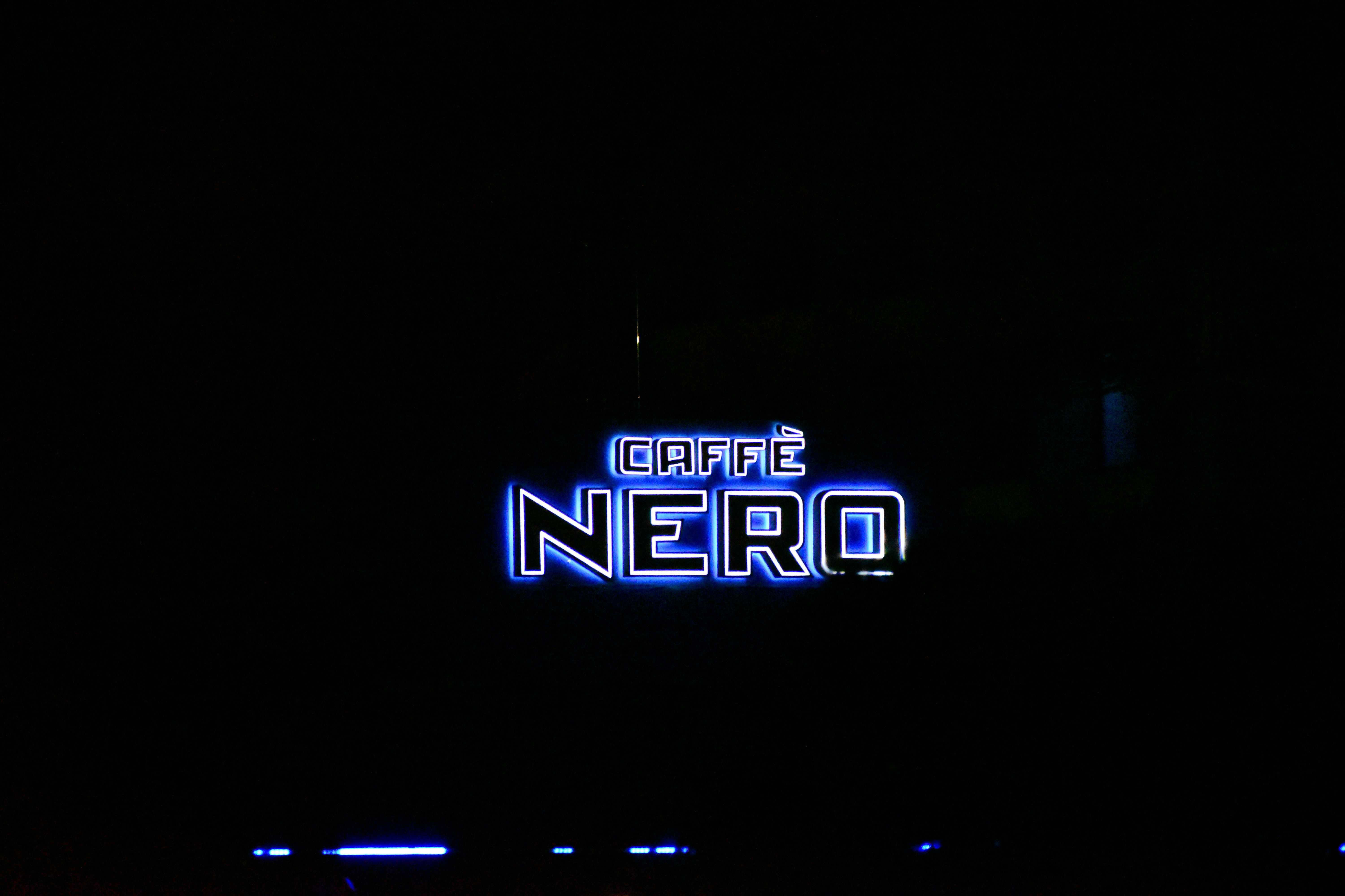 a neon sign is lit up in the dark