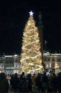 Community members singing carols together in a warmly lit plaza.