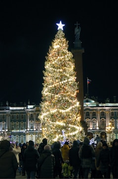 Community members singing carols together in a warmly lit plaza.
