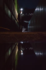 A lone warrior standing strong in a dark alley illuminated by red neon lights, embodying mental toughness.