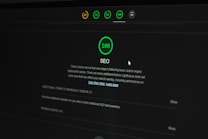 A dark-themed web interface displays an SEO performance score of 100. Multiple indicators at the top show different scores in circular icons. Text below explains the significance of the SEO score and offers additional actions to improve website optimization. A cursor is partially visible.