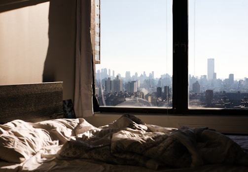 a view of a city from a bedroom window