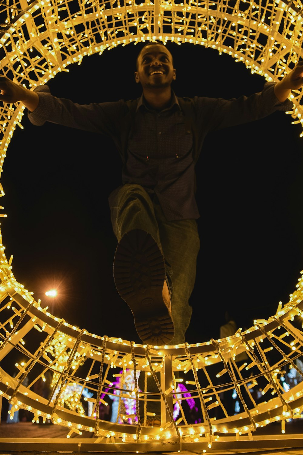 a man standing on a metal structure with lights around it