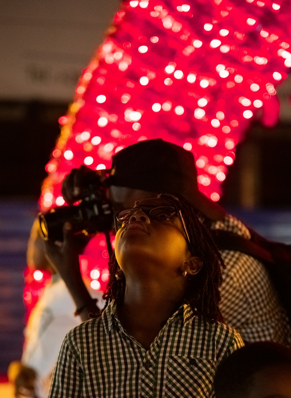 a person with a camera in front of a tree