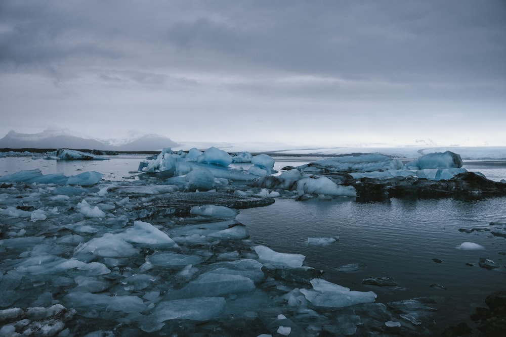 a group of icebergs floating on top of a body of water